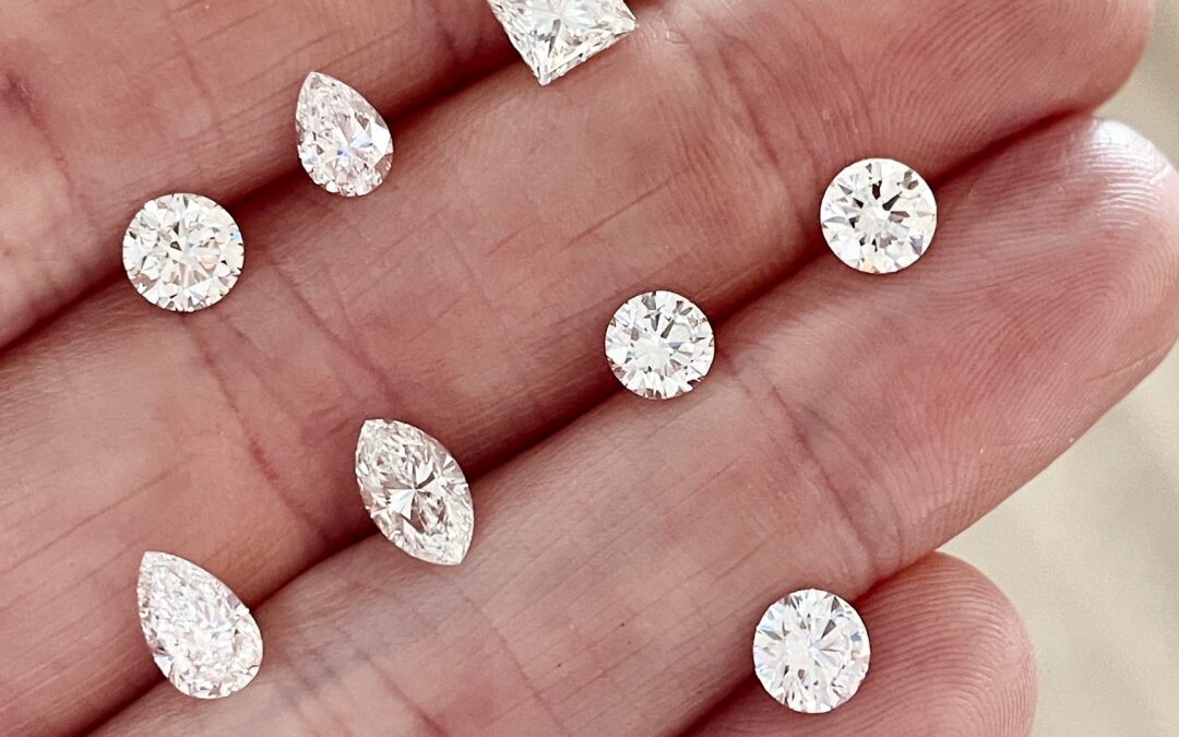 Loose natural diamonds in a mix of shapes and sizes resting on the palm of a hand